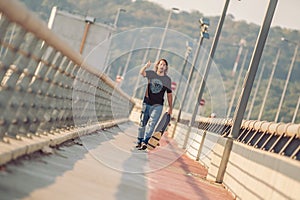 Skateboarder skates over a city bridge. Free ride street skateboarding