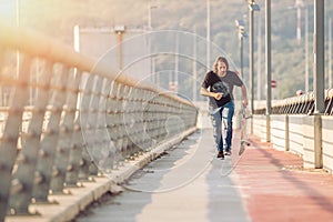 Skateboarder skates over a city bridge. Free ride street skateboarding