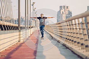 Skateboarder skates over a city bridge. Free ride street skateboarding