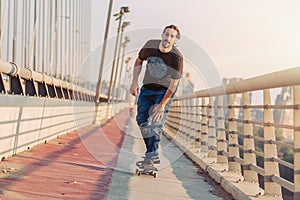 Skateboarder skates over a city bridge. Free ride street skateboarding