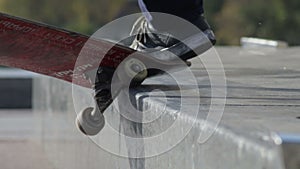 Skateboarder try a grind trick on ledge and skate truck stops slide, slowmotion