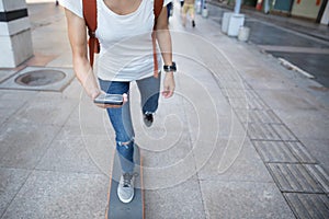 Skateboarder use smartphone while riding skateboard
