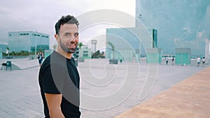 Skateboarder walks with skateboard in the modern city street