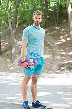 Skateboarding for extreme freedom and drive. Athletic man hold penny board outdoors. Skateboarding sport and activity