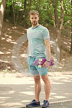Skateboarding for extreme freedom and drive. Athletic man hold penny board outdoors. Skateboarding sport and activity