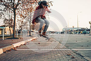 Skateboarding. A man does an Ollie stunt on a skateboard. Jump in the air. Street on the background