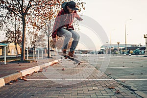 Skateboarding. A man does an Ollie stunt on a skateboard. Jump in the air. Street on the background photo