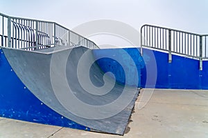 A Skateboarding ramp with railings against sky