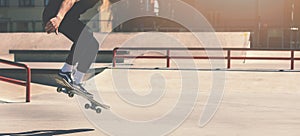 Skateboarding - skateboarder doing trick jumping at city skate park photo