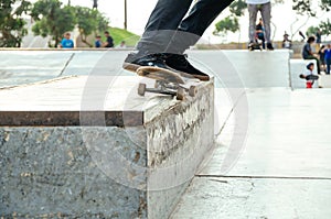 Skater doing a trick in the skatepark called grind o 50 - 50.