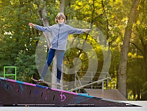 Skater girl on skatepark moving on skateboard outdoors.