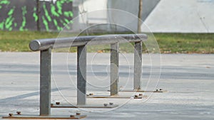 Skater make trick boardslide on rail in skatepark, close-up view in slowmotion