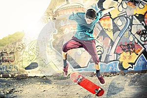 Skater in movement making a trick with his skate at sunset