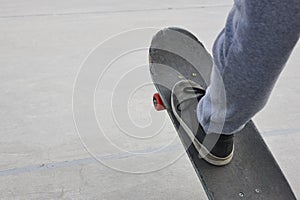 Skater and skateboard leg detail. Lifestyle urban background.