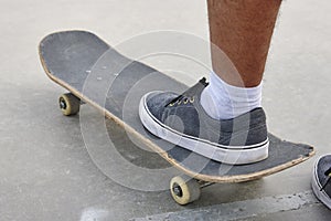 Skater and skateboard legs detail. Lifestyle urban background.