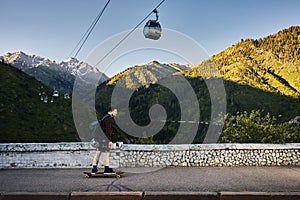 Skater traveling in the mountains on his longboard