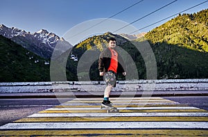 Skater traveling in the mountains on his longboard