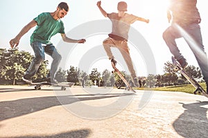 Skaters jumping with skateboard in city skate park - Young guys performing tricks and skills at sunset in suburb contest - Extreme