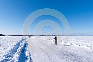 Skaters on lake on clear winter day photo