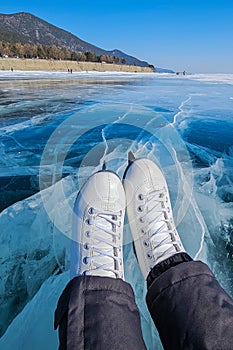 Skates close up on the ice of a frozen lake. Winter landscape, sunny day, atmosphere of fun winter activities.