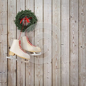 Skates hanging on the wooden planks wall with garland, winter Christmas background