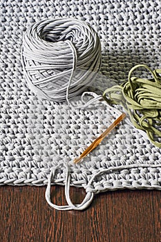 Skein of grey knitted yarn and a crochet hook