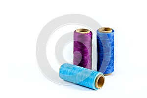 A skein of purple, blue and cyan thread. Coils of colored threads on a white background. Waxed sewing thread for leather