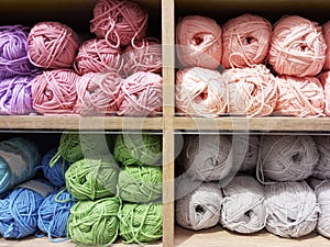 Skeins of yarn on  wooden rack on a store counter close-up
