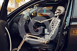 Skeleton in car with opened door, gas station