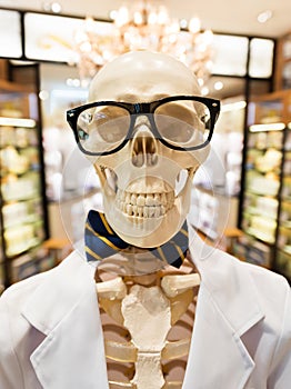 Skeleton in doctors smock with glasses and bow tie photo