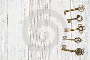 Skeleton keys on weathered whitewash wood background with grain texture