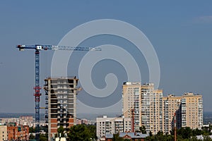 The skeleton of a new multi-storey residential building under construction next to a large multi-apartment inhabited and new build