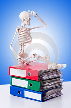 Skeleton with pile of files against gradient