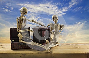 Skeleton pirate sitting on a treasure chest and old wood floor,blue sky background.