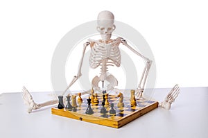 The skeleton playing chess game on white