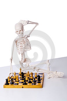 The skeleton playing chess game on white