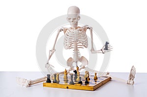 The skeleton playing chess game on white