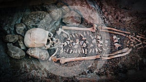 Skeleton of a primitive man inside a cave.