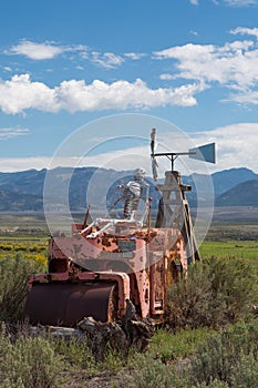 Skeleton sitting on a vintage tractor in Utah with mountains