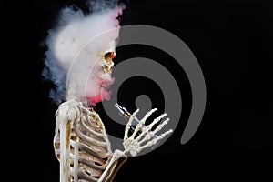 Skeleton vaping clouds of red highlighted vapor with an ecigarette photo
