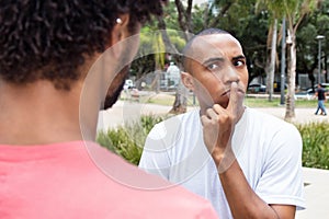 Skeptical african american man in discussion with friend