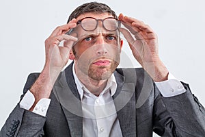 Skeptical businessman with eyeglasses on his forehead for suspicion