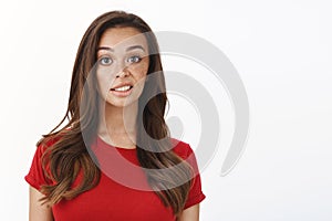 Skeptical displeased young picky feminine woman in red t-shirt, express disdain and scorn, look disappointed, slightly