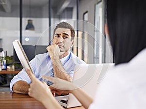 Skeptical interviewer looking at interviewee photo