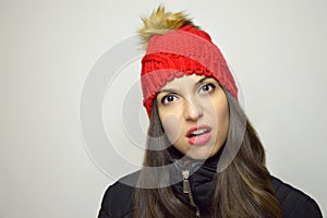Skeptical perplexed young woman. Doubtfully incredulous girl on gray background. photo