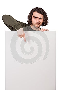 Skeptical young man pointing forefinger to a blank banner for advertising and messages. Empty sheet, copy space for text