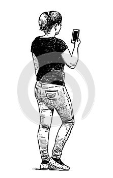 Sketch of young city woman in jeans standing and looking at smartphone outdoors, hand drawn vector illustration isolated on white