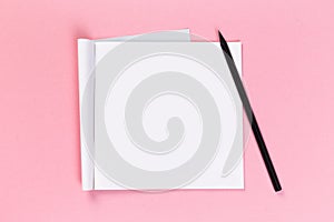 Top view of blank open notebook on pink background, concept of education or new workplace