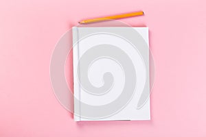Top view of blank open notebook on pink background, concept of education or new workplace