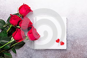 Sketchbook, red rose and decorative hearts on stone background Copy space Top view Valentine`s day card